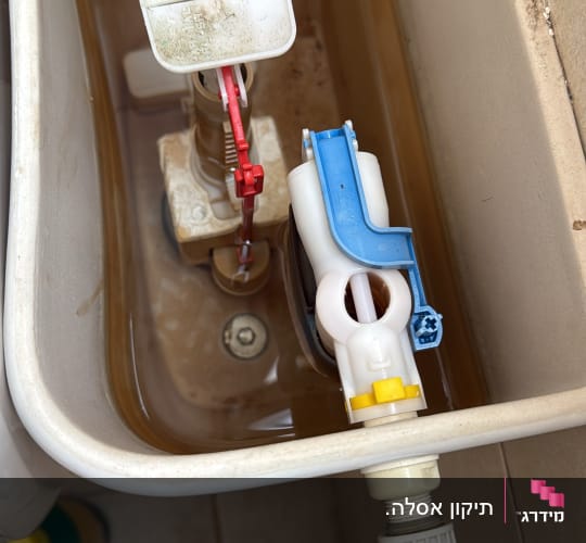 מיכל שירותים עם מים חומים ומנגנון פנימי